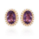 A PAIR OF AMETHYST AND PEARL CLIP EARRINGS in 18ct yellow gold, the central oval cut amethyst is