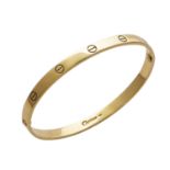 A LOVE BANGLE, CARTIER in 18ct yellow gold, the oval bangle punctuated with screw head motifs,