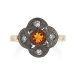 A CITRINE AND DIAMOND RING in yellow gold and silver, the round cut citrine accented by four