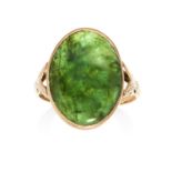 A JADE DRESS RING in 14ct yellow gold, set with an oval jade cabochon between foliate shoulders,