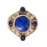 AN ANTIQUE CARVED SAPPHIRE CAMEO AND DIAMOND RING in yellow gold, set with a central carved sapphire