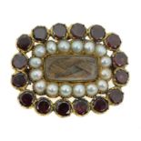 AN ANTIQUE HAIRWORK, PEARL AND GARNET MOURNING BROOCH, 19TH CENTURY in yellow gold, the central