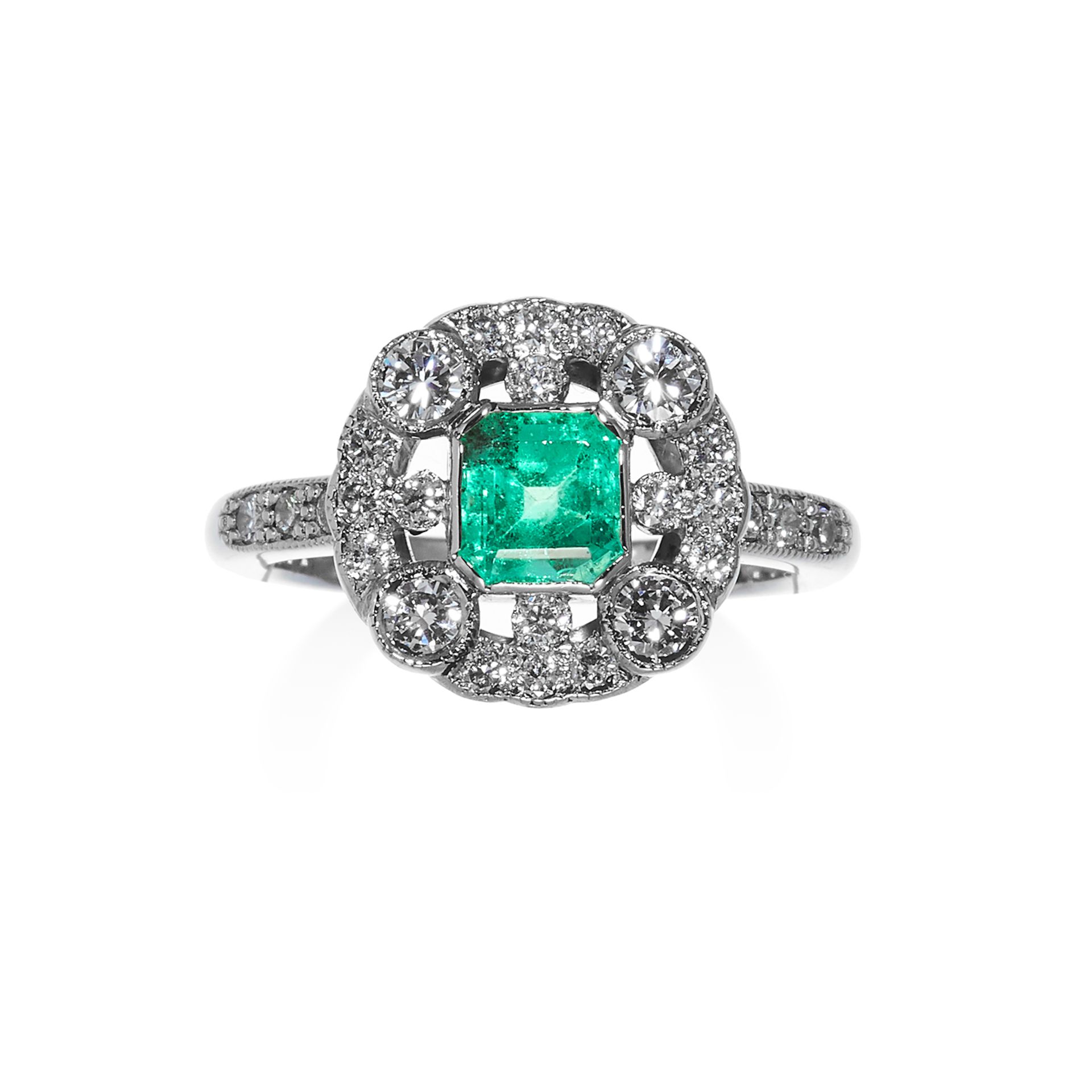 AN EMERALD AND DIAMOND DRESS RING in white gold, set with a step cut emerald encircled by round