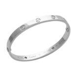 A DIAMOND LOVE BANGLE, CARTIER in 18ct white gold, the oval bangle punctuated with screw head