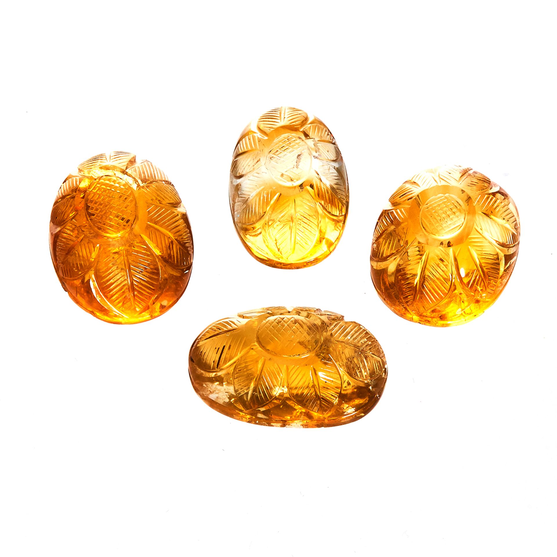 FOUR CARVED CABOCHON CITRINES totalling 81.50 carats.