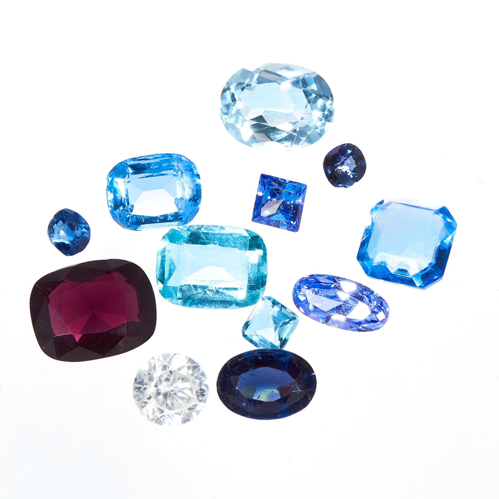 A 28.0 CARAT PARCEL OF GEMSTONES variously sized and shaped, including blue sapphires, topaz, etc,