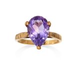 AN AMETHYST DRESS RING in yellow gold, set with a pear cut amethyst, British import hallmarks,