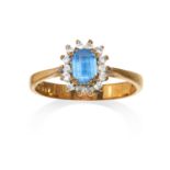 A TOPAZ CLUSTER RING in yellow gold the step cut topaz within a cluster surround, full British