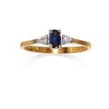 A SAPPHIRE AND DIAMOND THREE STONE RING in 18ct yellow gold, the oval cut sapphire between round cut