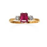 A RUBY AND DIAMOND THREE STONE RING in 18ct yellow gold and platinum, the step cut ruby between