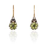 A PAIR OF PERIDOT AND DIAMOND EARRINGS in yellow gold and silver, each set with a peridot flower