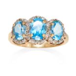 A TOPAZ DRESS RING in gold, set with a trio of graduated topaz clusters, unmarked, size Q / 8, 3.