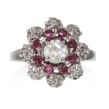 A DIAMOND AND RUBY RING in 18ct white gold, the central round cut diamond of approximately 0.50