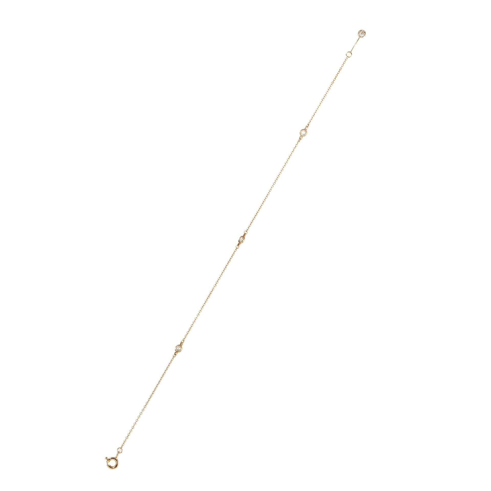 A DIAMOND BRACELET, TIFFANY & CO in 18 carat yellow gold, a fine gold chain holding three round