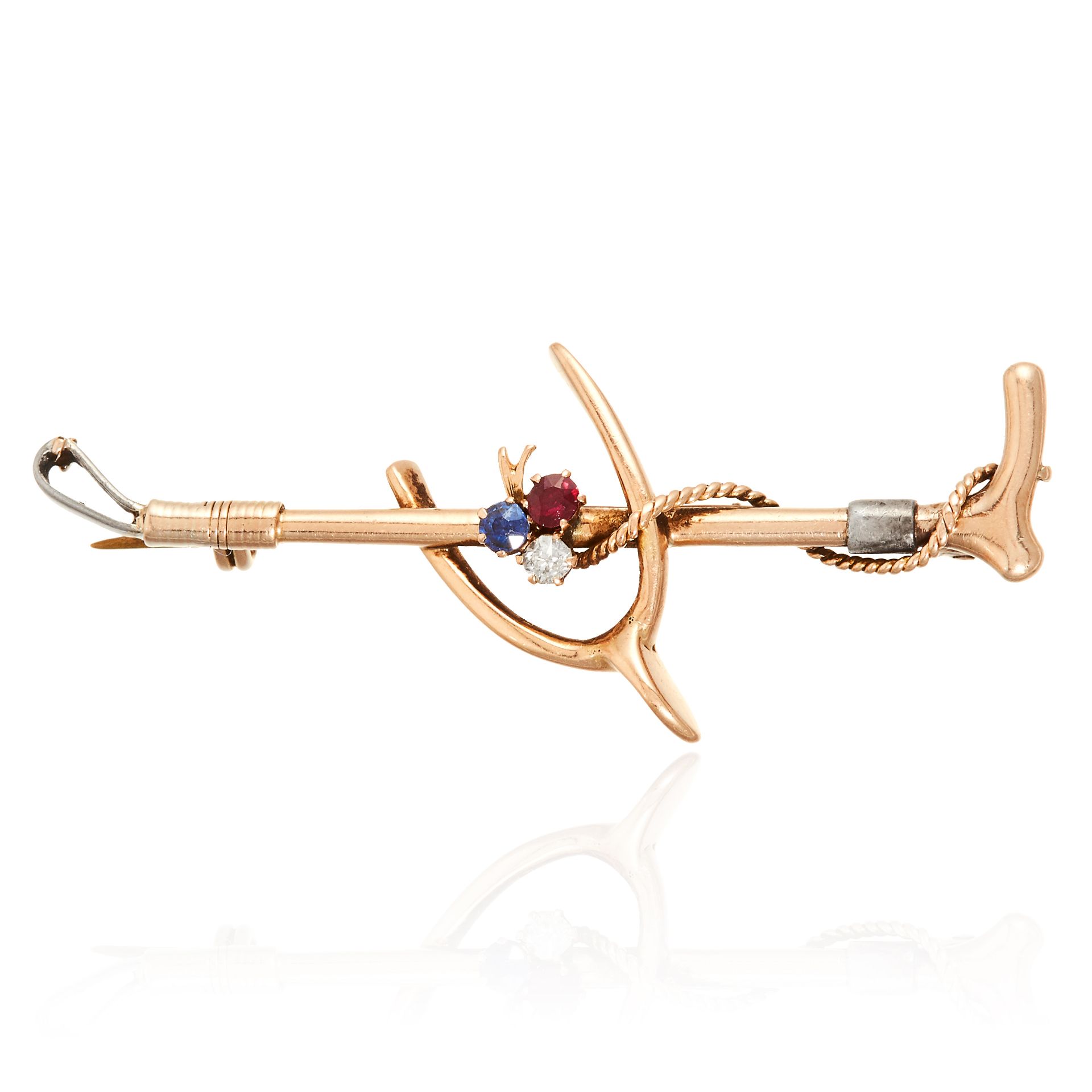 A RUBY, SAPPHIRE AND DIAMOND SPUR AND WHIP NOVELTY BROOCH in yellow gold, designed as spur and whip,