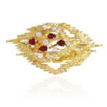 A RUBY AND DIAMOND BROOCH / PENDANT, CIRCA 1976 in 18ct yellow gold, in abstract design, jewelled