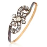 AN ANTIQUE DIAMOND BANGLE, 19TH CENTURY in high carat yellow gold, the scrolling motif jewelled with