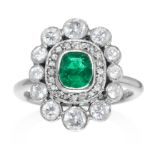 AN EMERALD AND DIAMOND DRESS RING in platinum, jewelled with an oval cut emerald framed in a diamond