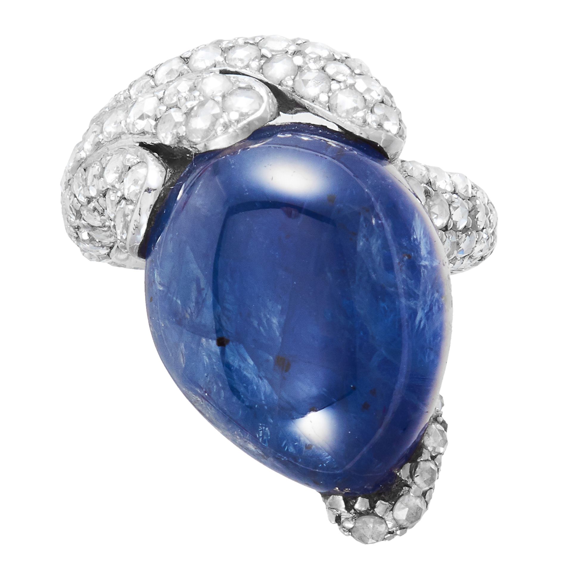 A SAPPHIRE AND DIAMOND DRESS RING in 18ct gold, the abstract design set with a cabochon sapphire