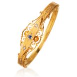 AN ANTIQUE SAPPHIRE AND DIAMOND BANGLE, 1908 in 15ct yellow gold, set with a trio of stones