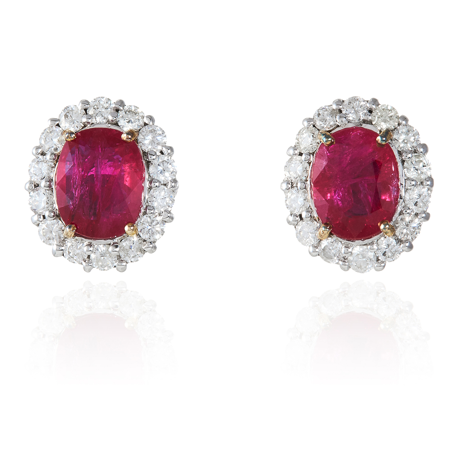 A PAIR OF RUBY AND DIAMOND CLUSTER EARRINGS in 18ct white gold, each set with an oval cut ruby