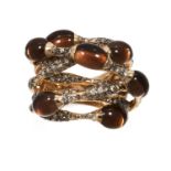 A SMOKEY QUARTZ AND DIAMOND RING in 18ct yellow gold, comprising of eight twisted bands jewelled