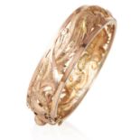 AN ANTIQUE CHINESE BANGLE / BRACELET in high carat yellow gold, with pierced and chased dragon