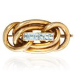 A VINTAGE AQUAMARINE BROOCH in 14ct yellow gold, in scrolling rope motif jewelled with six emerald
