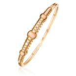 AN ANTIQUE CORAL AND PEARL BANGLE in 18ct yellow gold, set with graduated coral cabochons