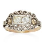 AN ANTIQUE DIAMOND RING in platinum or white gold, set with four diamonds among scrolling motifs,