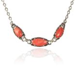 A CORAL NECKLACE in sterling silver, the three coral cabochons within foliate surrounds, unmarked,