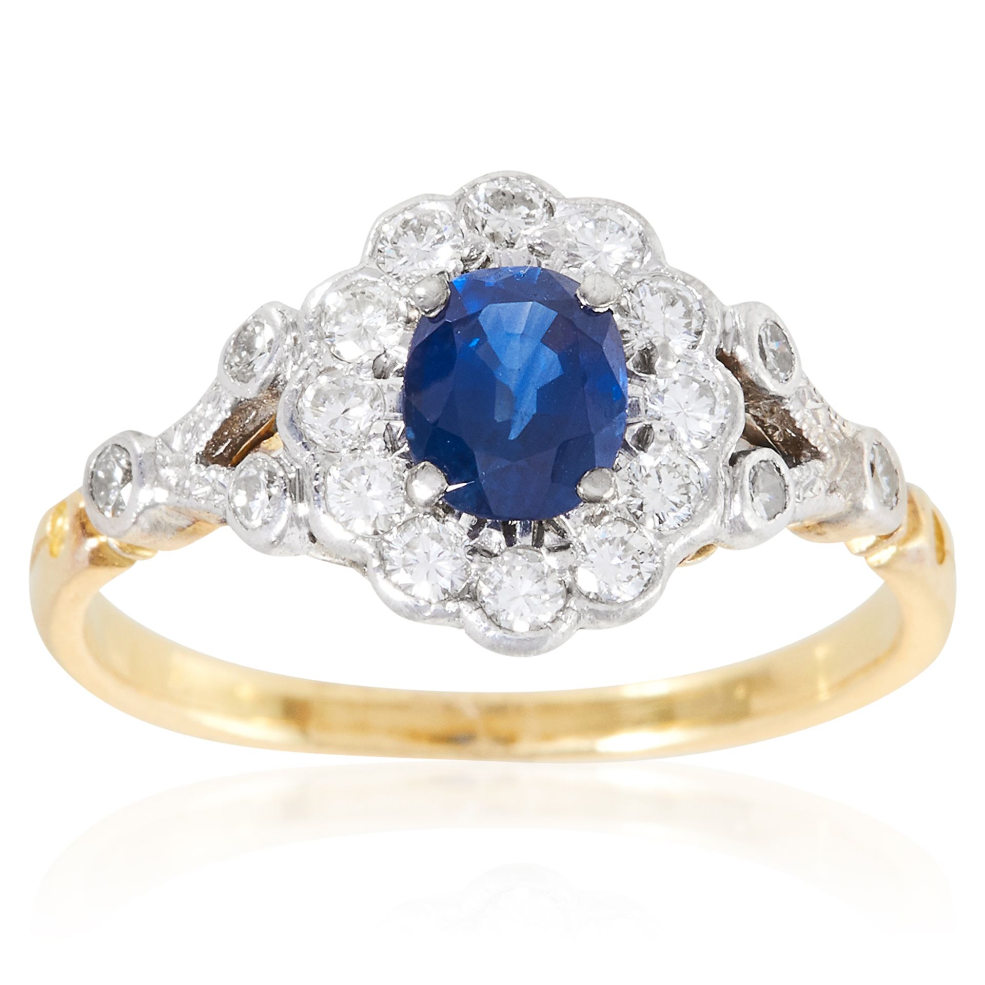 A SAPPHIRE AND DIAMOND CLUSTER RING in high carat yellow gold, set with an oval cut sapphire of