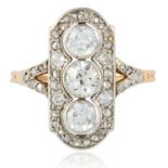 AN ART DECO DIAMOND RING in yellow gold and platinum, set with a trio of round cut diamonds