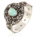 AN ARTS AND CRAFTS TURQUOISE BANGLE in sterling silver, set with a cabochon turquoise in floral