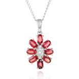 A GARNET AND DIAMOND CLUSTER PENDANT in white gold, depicting floral cluster jewelled with round cut