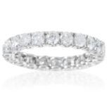 A DIAMOND ETERNITY RING in 18ct white gold, jewelled with round cut diamonds totalling approximately