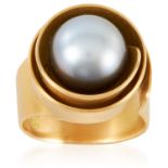 A PEARL RING in 18ct yellow gold, set with a 10.7mm great pearl within an abstract scrolling