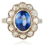 AN ANTIQUE BLUE STONE AND DIAMOND RING in yellow gold and silver, the oval cut stone within a border