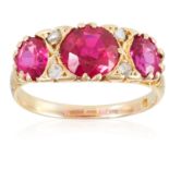 AN EDWARDIAN THREE RED STONE AND DIAMOND RING, in 18ct yellow gold, set with three round cut red