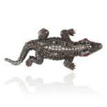 A RUBY AND DIAMOND ALLIGATOR BROOCH in 18ct gold, the body jewelled with round cut black and white