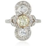 AN ART DECO THREE STONE DIAMOND RING in yellow gold and platinum, set with a central light yellow