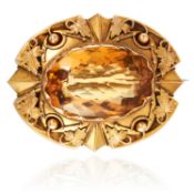 AN ANTIQUE CITRINE BROOCH in high carat yellow gold, set with an oval cut citrine in scrolling and