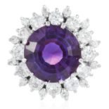 AN AMETHYST AND DIAMOND RING in white gold or platinum, set with a central round cut amethyst of