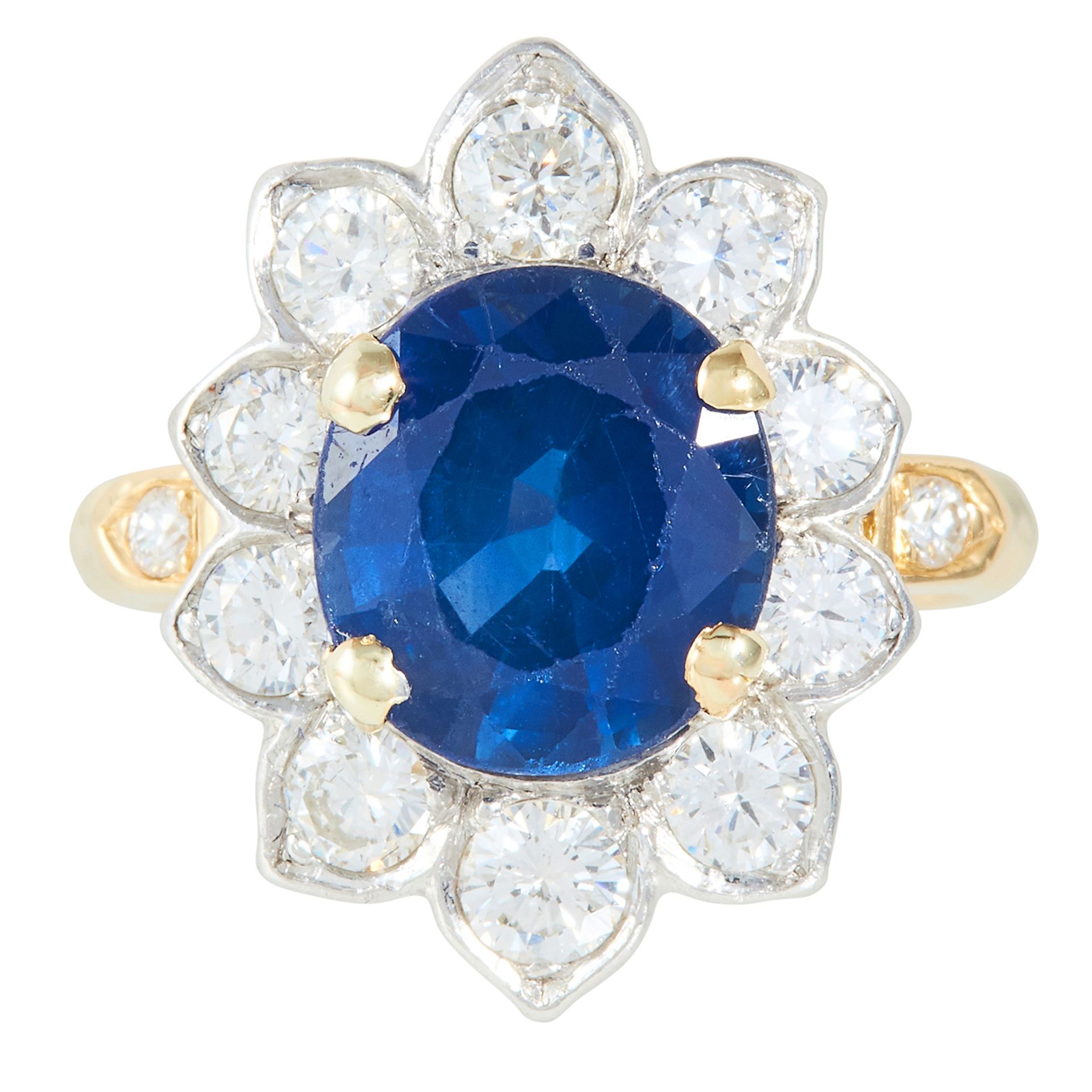 A 3.25 CARAT SAPPHIRE AND DIAMOND CLUSTER RING in yellow gold, set with an oval cut sapphire of