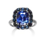 A TANZANITE AND SAPPHIRE CLUSTER RING in white gold or platinum, set with a cushion cut tanzanite of