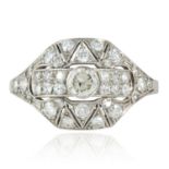 A DIAMOND DRESS RING in platinum or white gold, the central round cut diamond within geometric Art