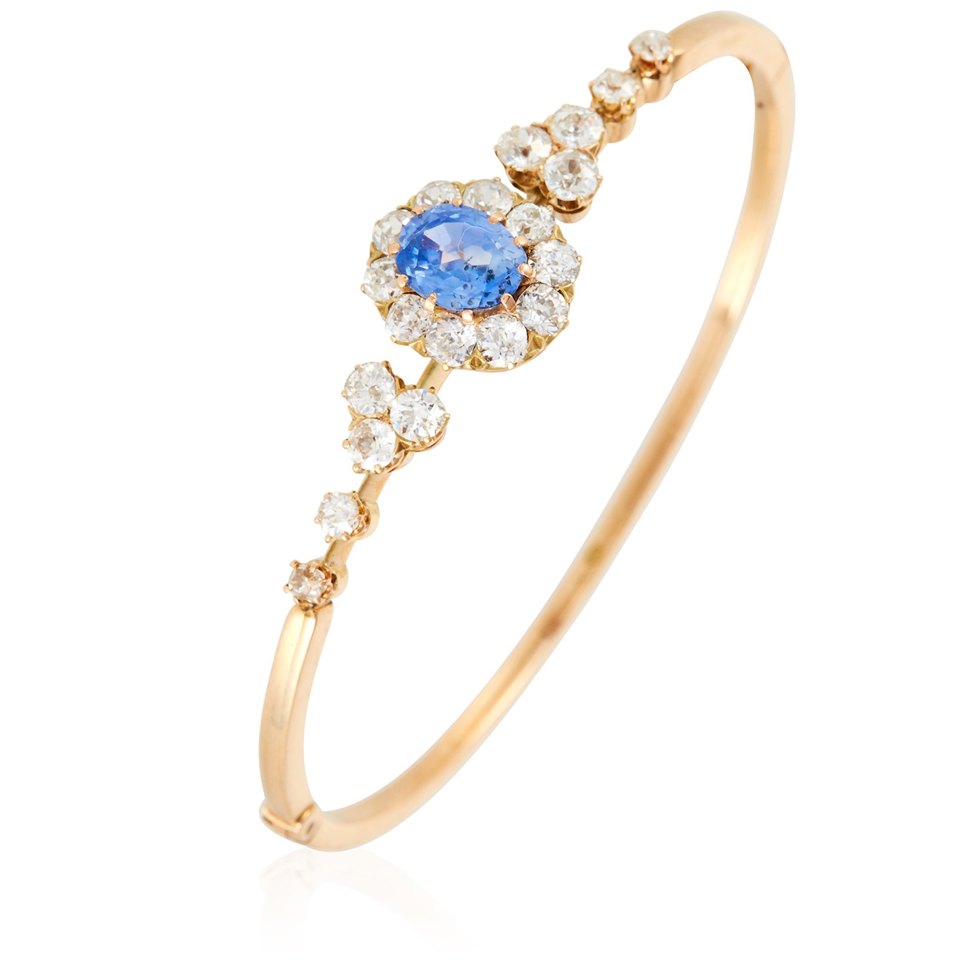 AN ANTIQUE CEYLON NO HEAT SAPPHIRE AND DIAMOND BANGLE in high carat yellow gold, set with an oval