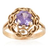A GEM SET RING in yellow gold, set with a round cut colour change synthetic sapphire, unmarked, size