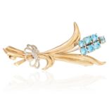 A BLUE GEMSTONE AND DIAMOND BROOCH in 9ct yellow gold, in foliate design, set with seven round cut