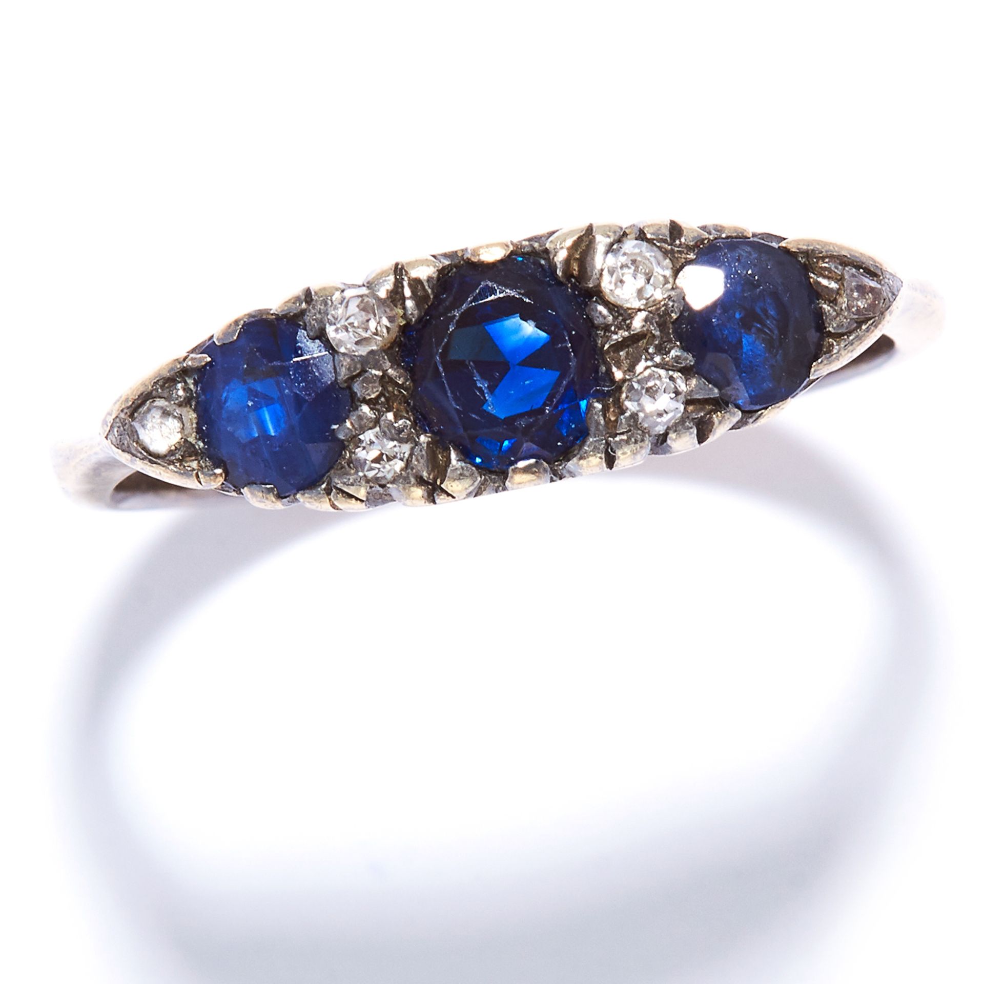 A SAPPHIRE AND DIAMOND DRESS RING in yellow gold, set with three round cut sapphires and alternating